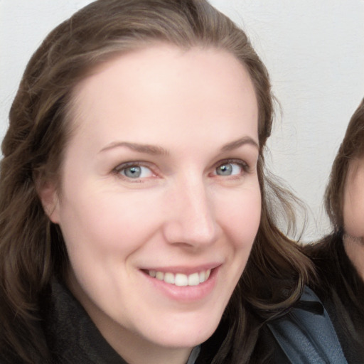 Joyful white young-adult female with long  brown hair and blue eyes