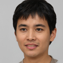 Joyful asian young-adult male with short  black hair and brown eyes