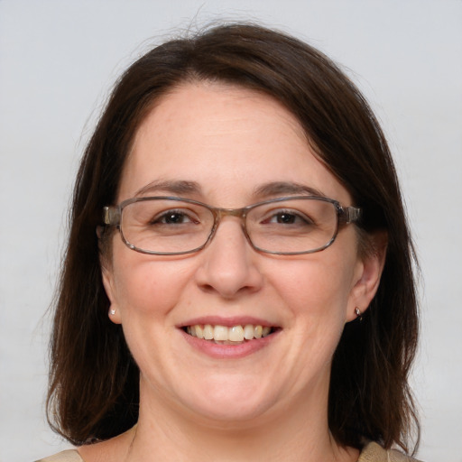 Joyful white adult female with medium  brown hair and blue eyes