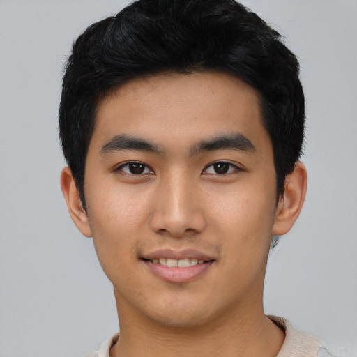Joyful asian young-adult male with short  black hair and brown eyes