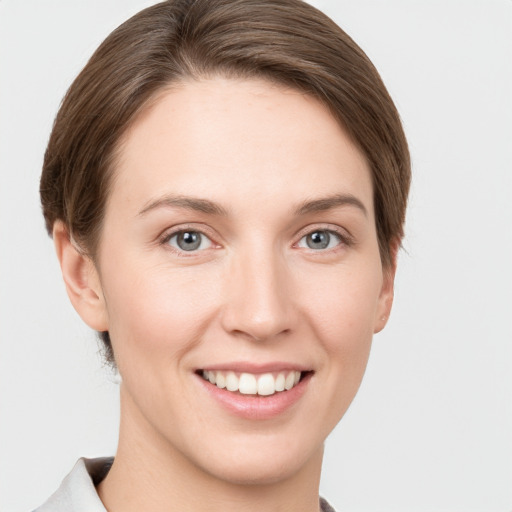 Joyful white young-adult female with short  brown hair and grey eyes