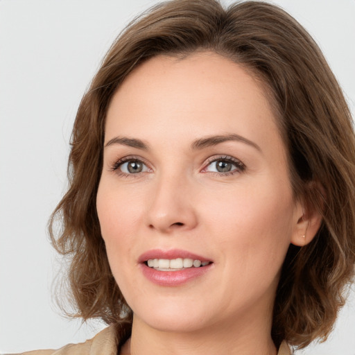 Joyful white young-adult female with medium  brown hair and green eyes