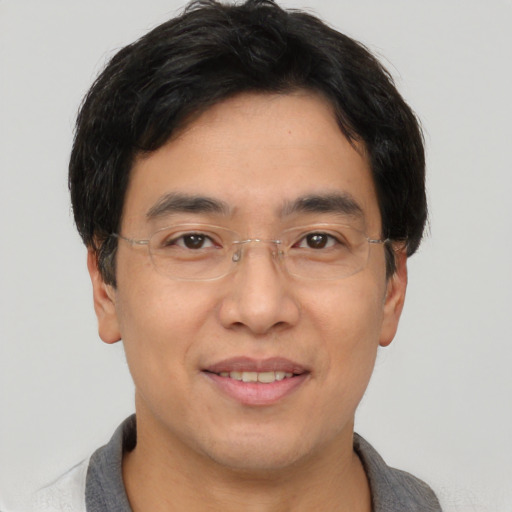 Joyful asian adult male with short  brown hair and brown eyes
