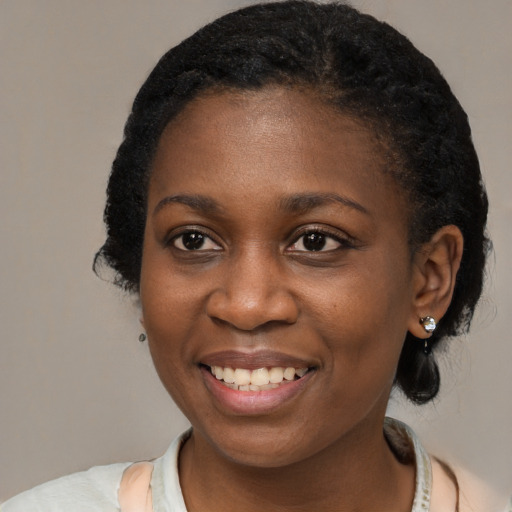 Joyful black young-adult female with short  black hair and brown eyes