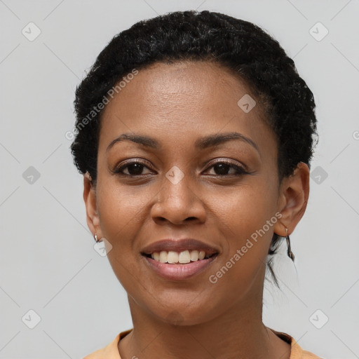 Joyful black young-adult female with short  black hair and brown eyes