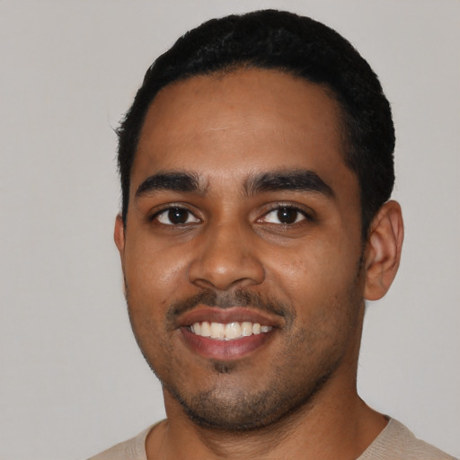 Joyful black young-adult male with short  black hair and brown eyes