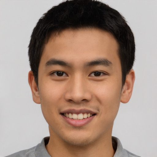 Joyful asian young-adult male with short  black hair and brown eyes