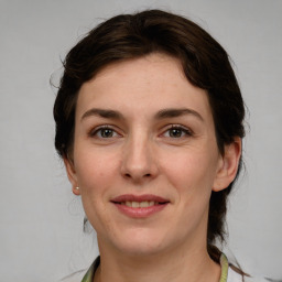 Joyful white young-adult female with medium  brown hair and green eyes