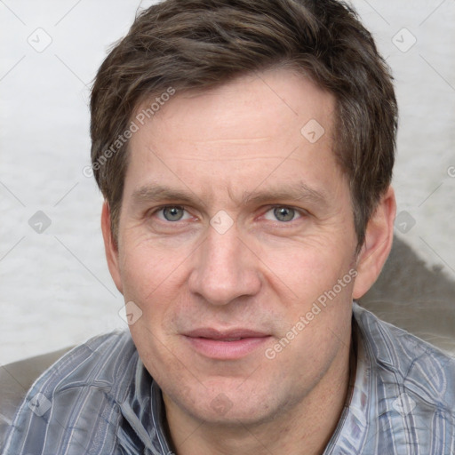 Joyful white adult male with short  brown hair and grey eyes