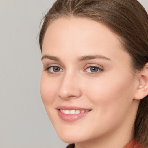 Joyful white young-adult female with long  brown hair and grey eyes