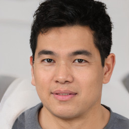 Joyful asian young-adult male with short  black hair and brown eyes