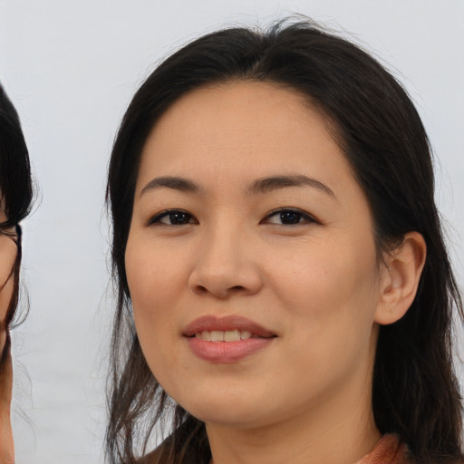 Joyful asian young-adult female with long  brown hair and brown eyes