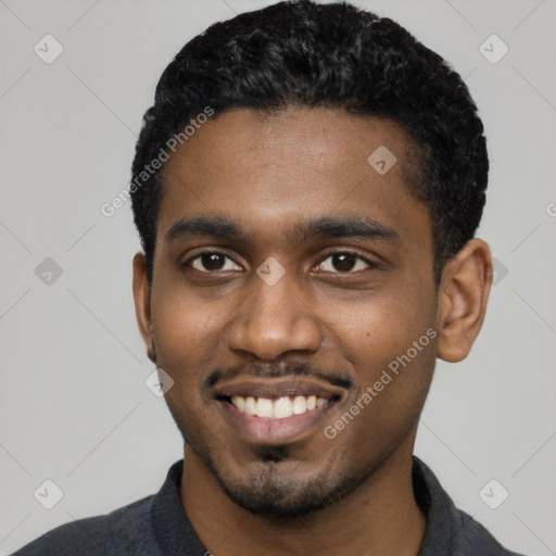 Joyful black young-adult male with short  black hair and brown eyes