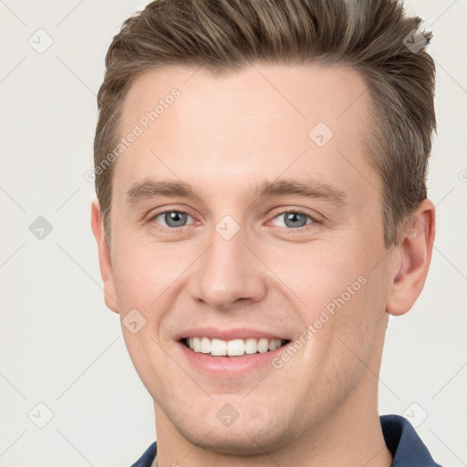 Joyful white young-adult male with short  brown hair and grey eyes