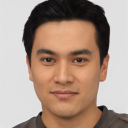 Joyful asian young-adult male with short  black hair and brown eyes