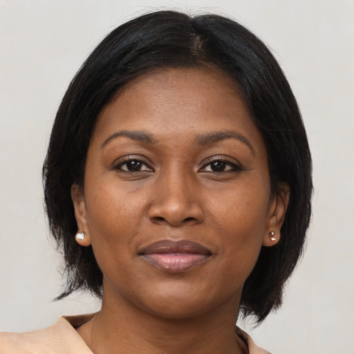 Joyful black adult female with medium  brown hair and brown eyes