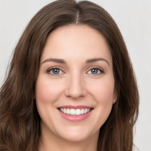 Joyful white young-adult female with long  brown hair and green eyes