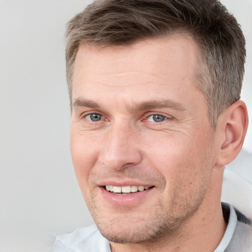 Joyful white adult male with short  brown hair and brown eyes