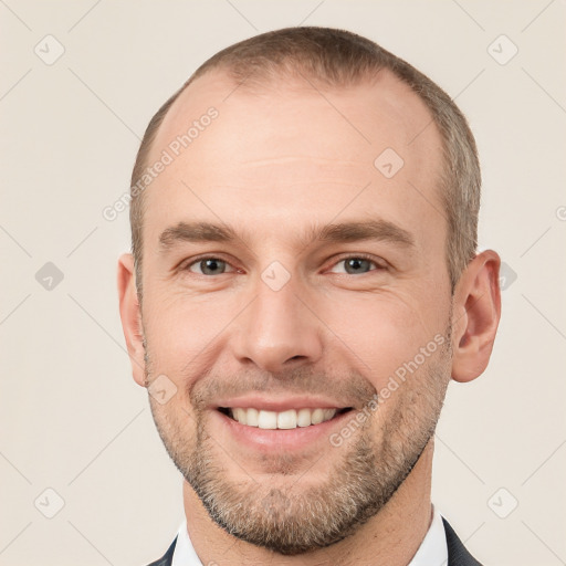 Joyful white young-adult male with short  brown hair and grey eyes