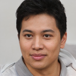 Joyful asian young-adult male with short  brown hair and brown eyes