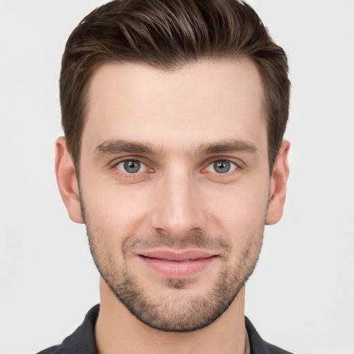 Joyful white young-adult male with short  brown hair and grey eyes