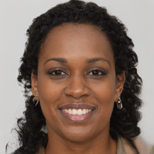 Joyful black adult female with long  brown hair and brown eyes