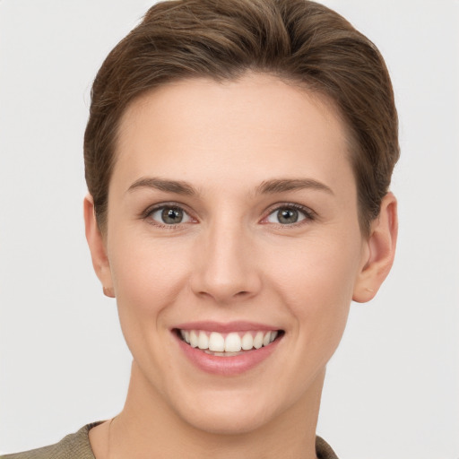 Joyful white young-adult female with short  brown hair and grey eyes