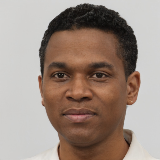 Joyful black young-adult male with short  black hair and brown eyes