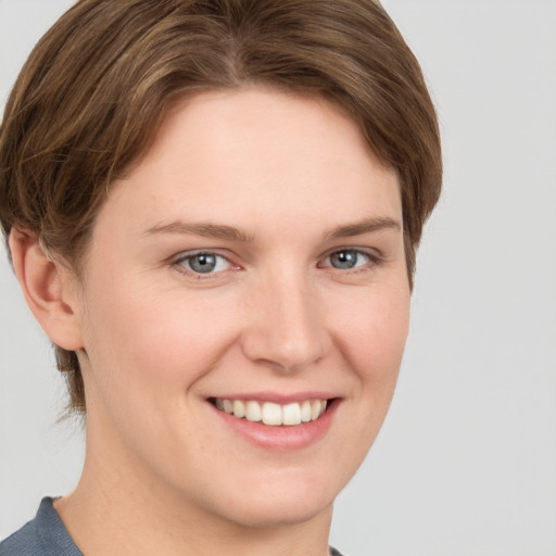 Joyful white young-adult female with short  brown hair and grey eyes