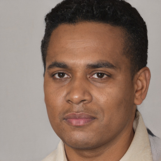 Joyful black young-adult male with short  black hair and brown eyes