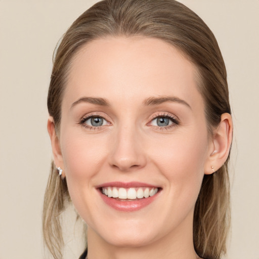 Joyful white young-adult female with long  brown hair and blue eyes