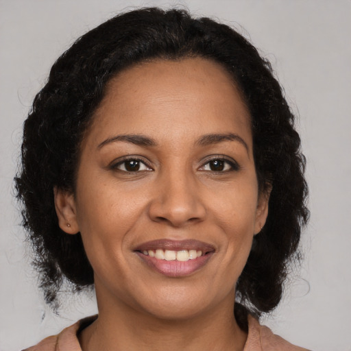 Joyful black adult female with medium  brown hair and brown eyes