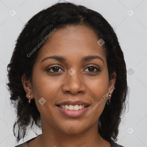 Joyful black young-adult female with long  brown hair and brown eyes