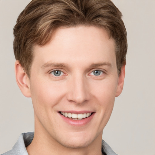 Joyful white young-adult male with short  brown hair and grey eyes