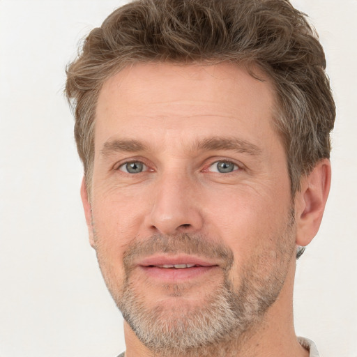 Joyful white adult male with short  brown hair and grey eyes