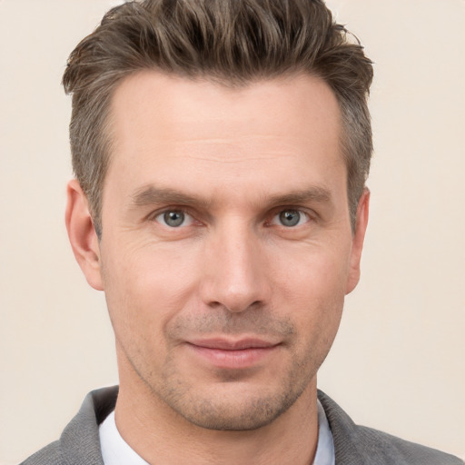 Joyful white adult male with short  brown hair and grey eyes