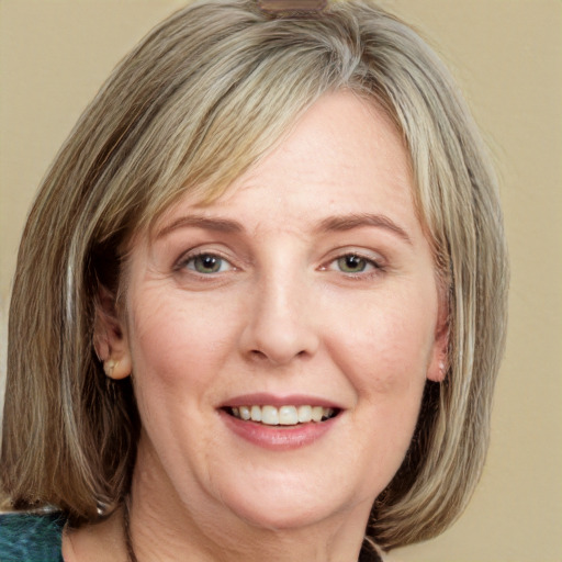 Joyful white adult female with medium  brown hair and green eyes