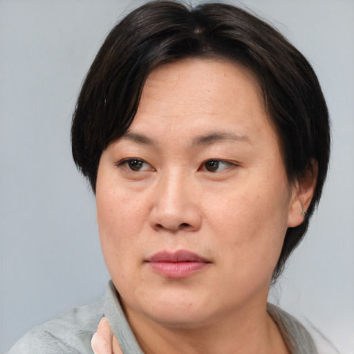 Joyful asian adult female with medium  brown hair and brown eyes