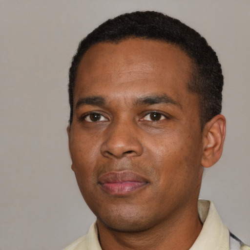 Joyful black young-adult male with short  black hair and brown eyes