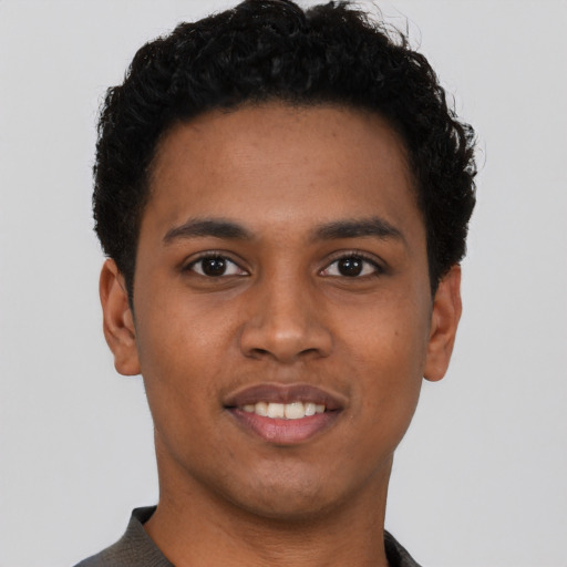 Joyful black young-adult male with short  brown hair and brown eyes