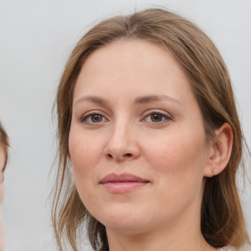 Joyful white young-adult female with medium  brown hair and grey eyes