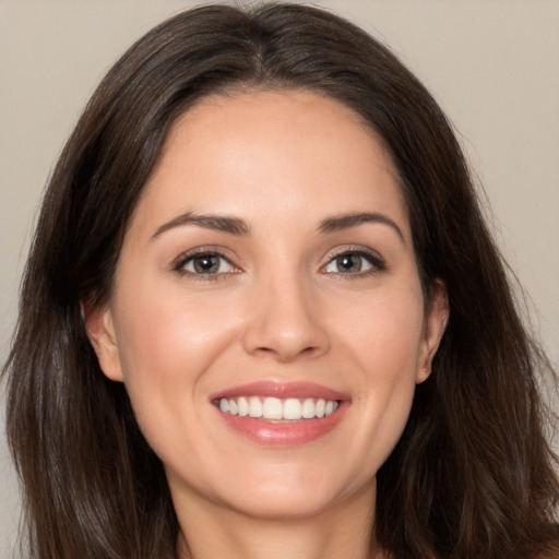 Joyful white young-adult female with long  brown hair and brown eyes