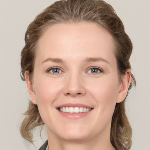 Joyful white young-adult female with medium  brown hair and grey eyes