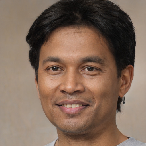 Joyful latino adult male with short  brown hair and brown eyes