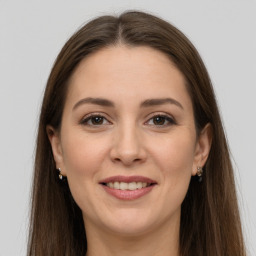 Joyful white young-adult female with long  brown hair and grey eyes