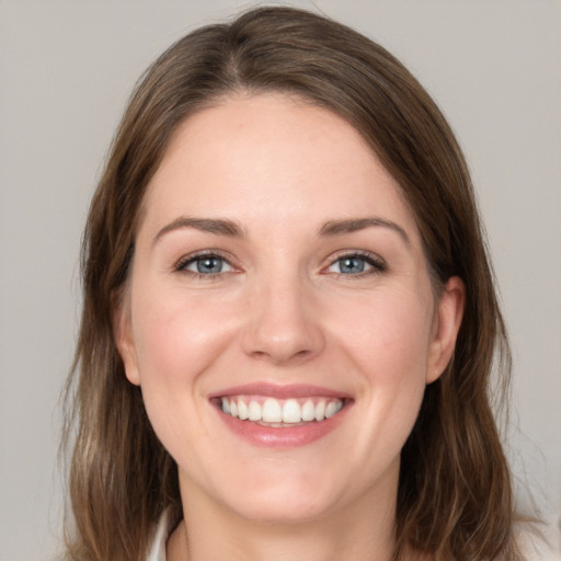 Joyful white young-adult female with medium  brown hair and grey eyes