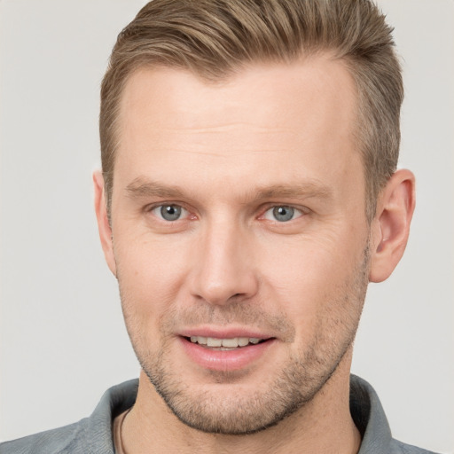 Joyful white adult male with short  brown hair and grey eyes