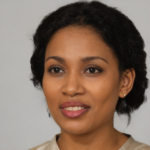 Joyful black adult female with short  black hair and brown eyes