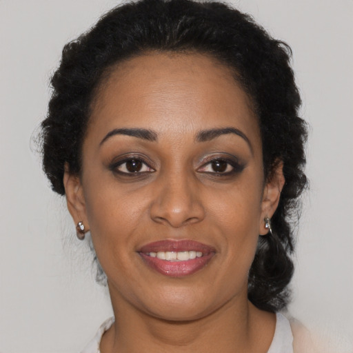 Joyful black young-adult female with medium  black hair and brown eyes