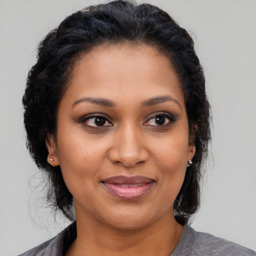 Joyful black young-adult female with medium  black hair and brown eyes